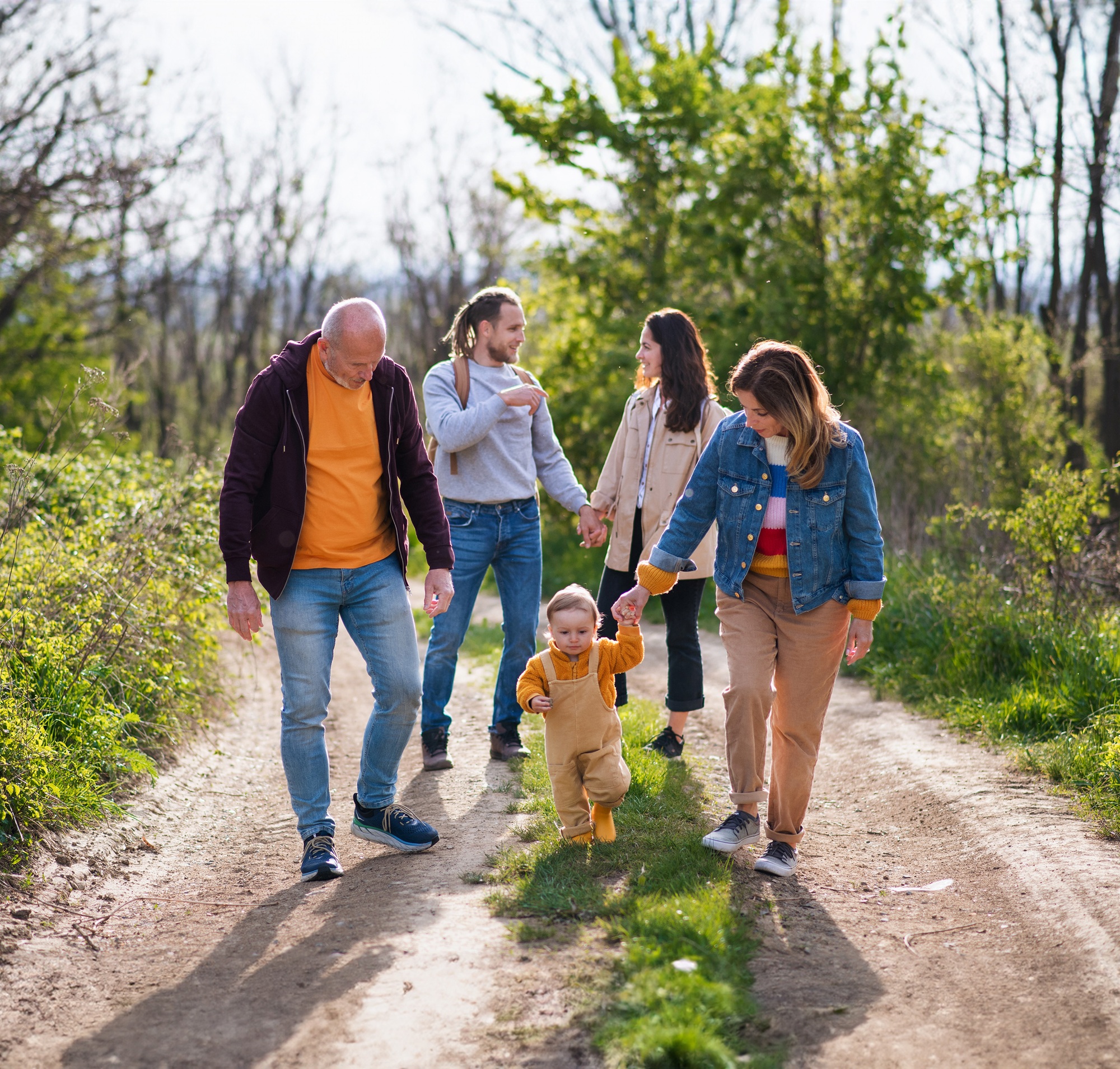 Małe dziecko z rodzicami i dziadkami na spacerze na świeżym powietrzu.