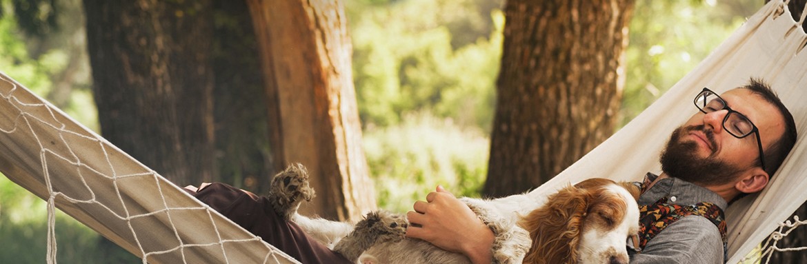 Mężczyzna odpoczywający z psem na hamaku