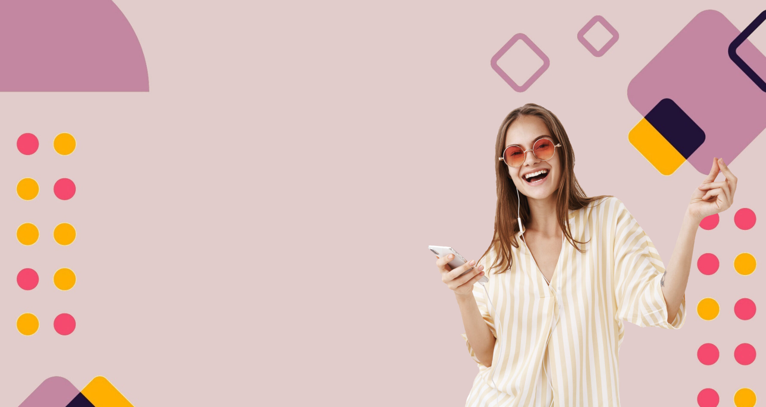 Radosna młoda kobieta w okularach przeciwsłonecznych i koszuli w paski, trzymająca w ręce smartfon, z słuchawkami na uszach