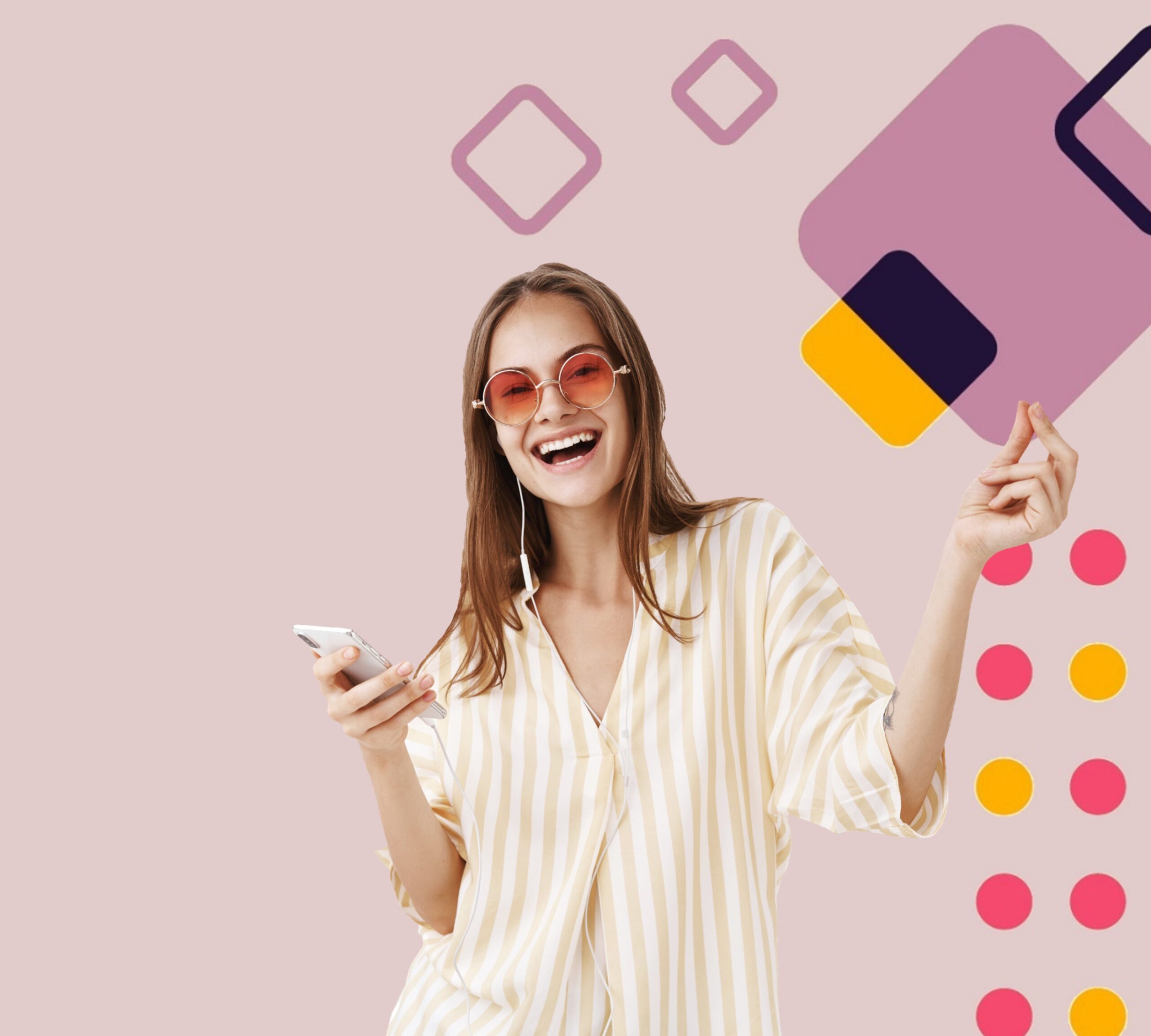 Radosna młoda kobieta w okularach przeciwsłonecznych i koszuli w paski, trzymająca w ręce smartfon, z słuchawkami na uszach