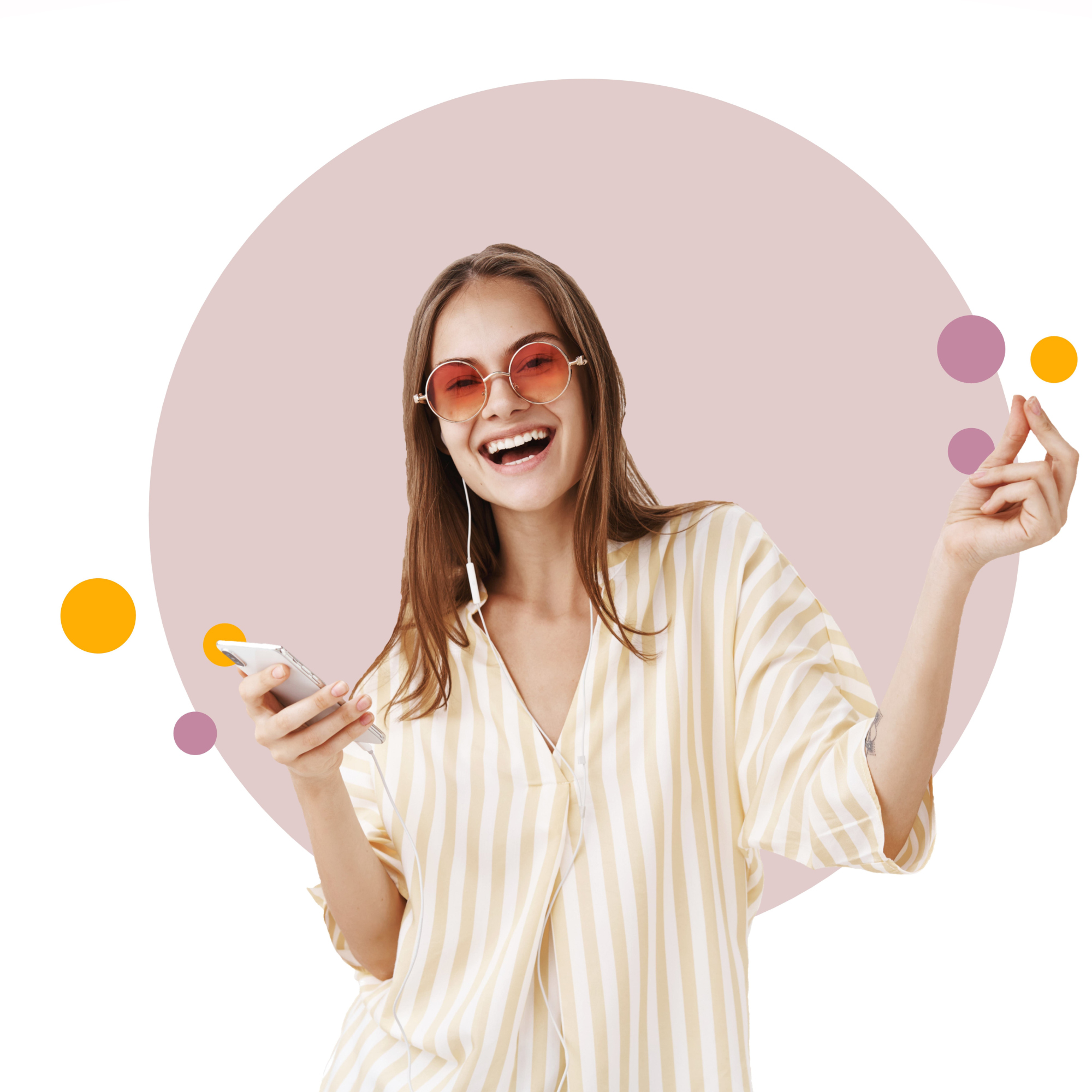 Radosna młoda kobieta w okularach przeciwsłonecznych i koszuli w paski, trzymająca w ręce smartfon, z słuchawkami na uszach